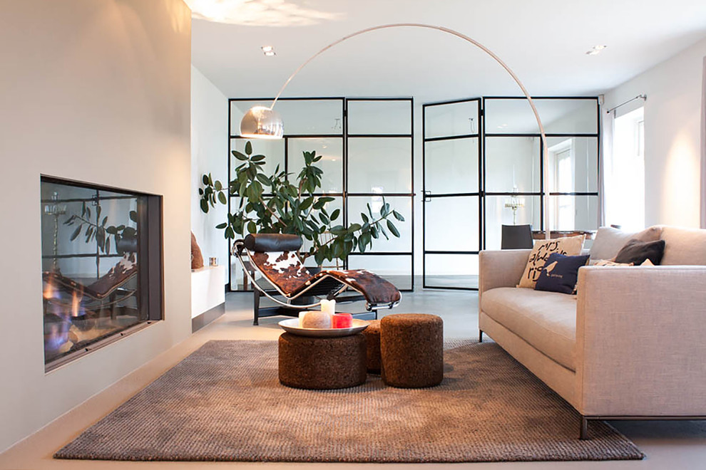 Inspiration for a mid-sized contemporary enclosed living room in Amsterdam with beige walls and a standard fireplace.