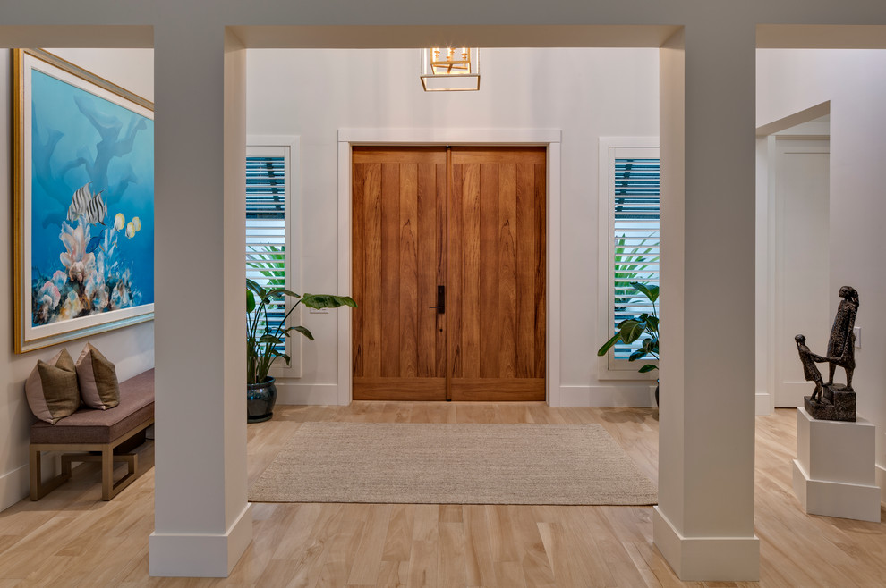 Large beach style foyer in Miami with white walls, porcelain floors, a double front door and a medium wood front door.