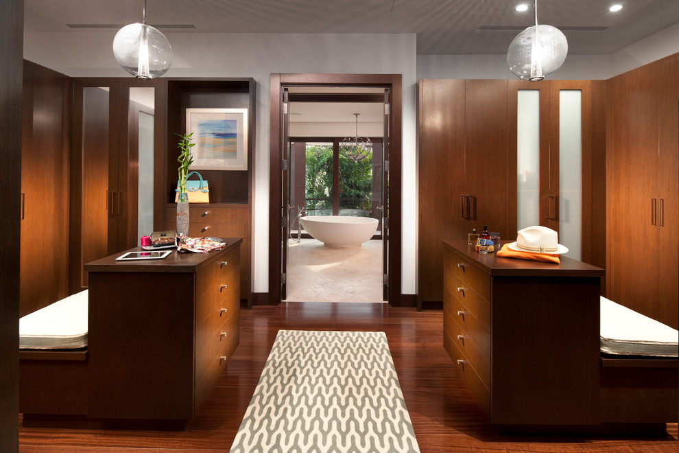 This is an example of a contemporary gender-neutral dressing room in Miami with flat-panel cabinets and dark wood cabinets.