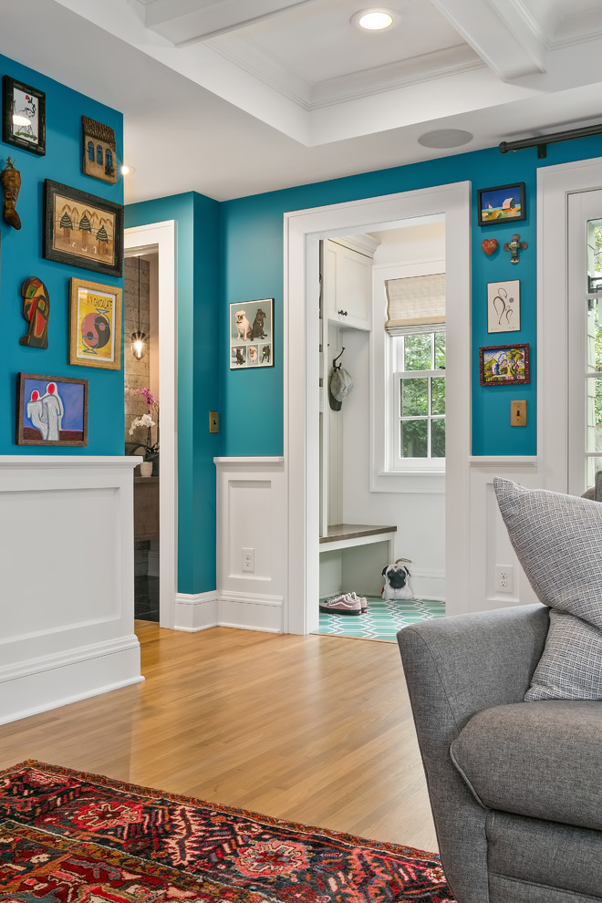 Design ideas for a mid-sized eclectic open concept family room in Minneapolis with blue walls, light hardwood floors, a standard fireplace, a tile fireplace surround, a wall-mounted tv and yellow floor.