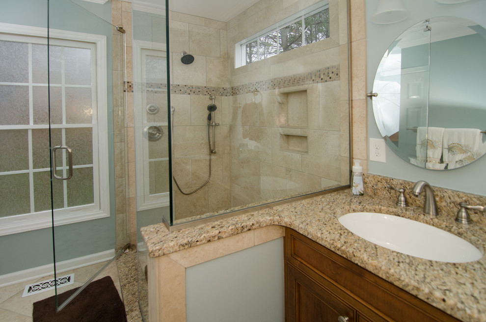 Photo of a contemporary bathroom in Raleigh with raised-panel cabinets, medium wood cabinets, granite benchtops, an alcove shower, beige tile and porcelain tile.