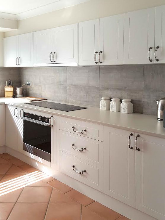 Inspiration for a large contemporary u-shaped eat-in kitchen in Sydney with a double-bowl sink, beige cabinets, laminate benchtops, ceramic splashback, stainless steel appliances, with island, beaded inset cabinets, grey splashback, terra-cotta floors and red floor.