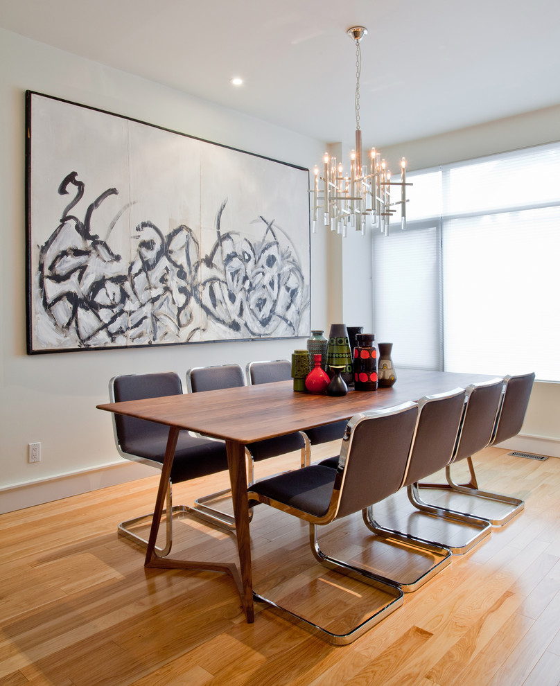 This is an example of a contemporary dining room in Toronto with white walls and medium hardwood floors.