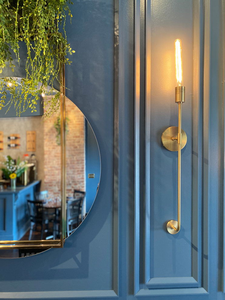 Exemple d'une salle à manger éclectique avec un mur bleu, parquet foncé et différents habillages de murs.
