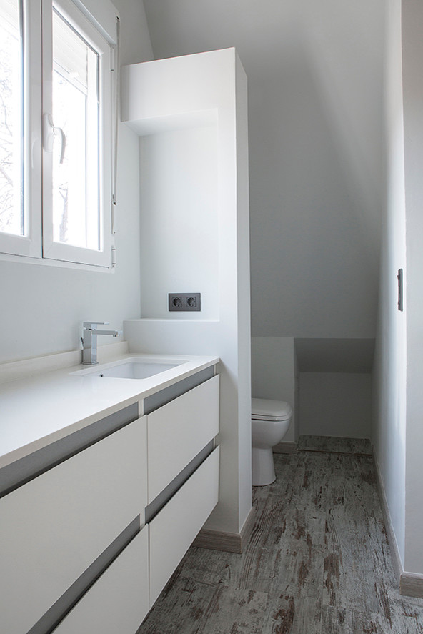 Photo of a small scandinavian powder room in Valencia with furniture-like cabinets, white cabinets, white walls, an integrated sink, ceramic tile, laminate floors and quartzite benchtops.