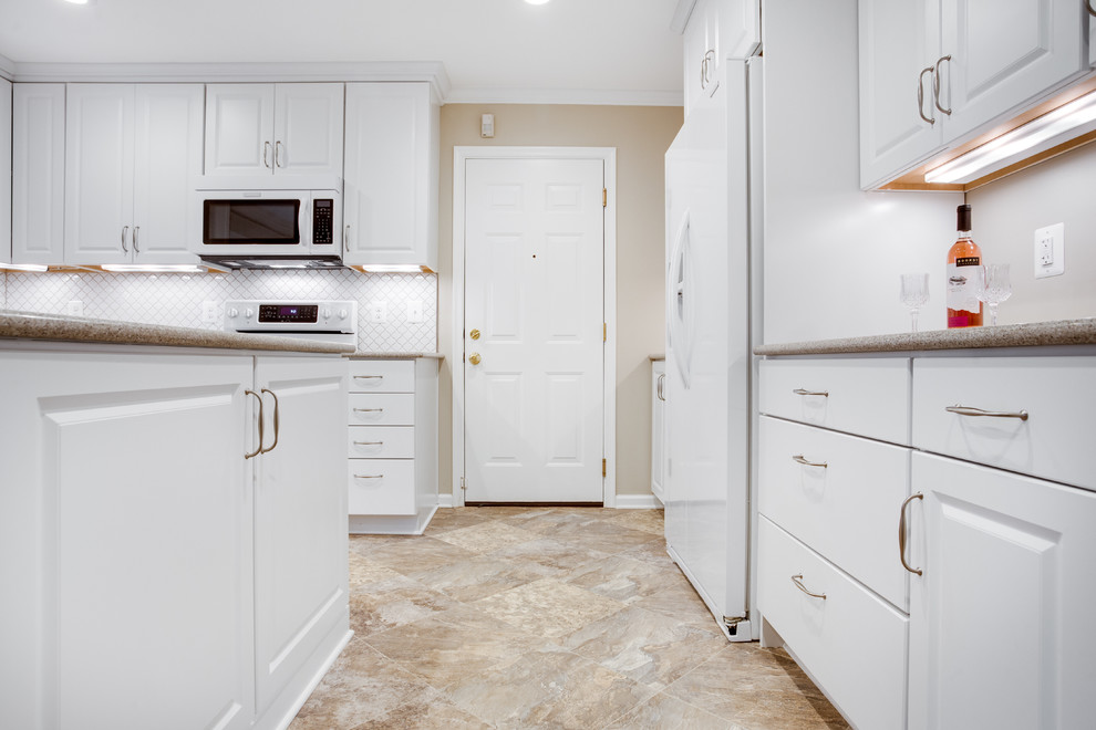 Design ideas for a mid-sized transitional u-shaped kitchen in DC Metro with an undermount sink, raised-panel cabinets, white cabinets, glass benchtops, white splashback, white appliances and with island.