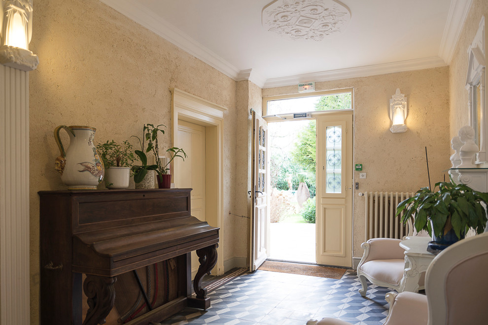 This is an example of a mid-sized traditional hallway in Paris with white walls and ceramic floors.