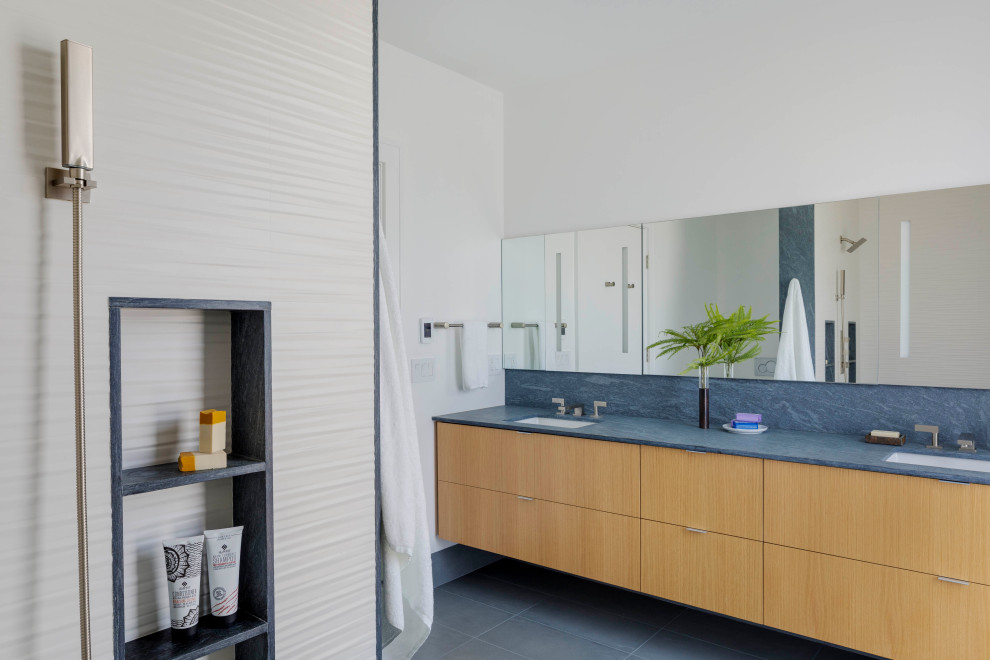 Photo of a beach style bathroom in Boston with flat-panel cabinets, light wood cabinets, white tile, white walls, an undermount sink, grey floor, blue benchtops, a niche, a double vanity and a floating vanity.