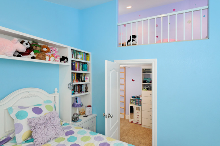 Design ideas for a mid-sized transitional kids' bedroom for kids 4-10 years old and girls in San Francisco with blue walls and carpet.