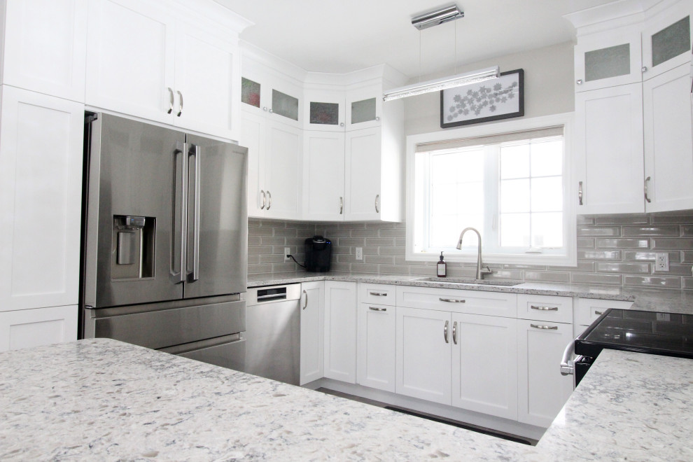 Example of an u-shaped kitchen design with shaker cabinets, white cabinets, quartzite countertops, gray backsplash, subway tile backsplash, a peninsula and gray countertops