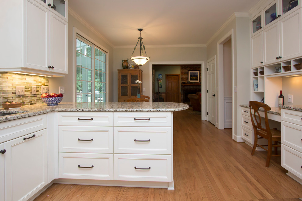Inspiration for a mid-sized transitional u-shaped eat-in kitchen in Raleigh with an undermount sink, recessed-panel cabinets, white cabinets, granite benchtops, grey splashback, glass tile splashback, stainless steel appliances, medium hardwood floors, a peninsula, orange floor and multi-coloured benchtop.