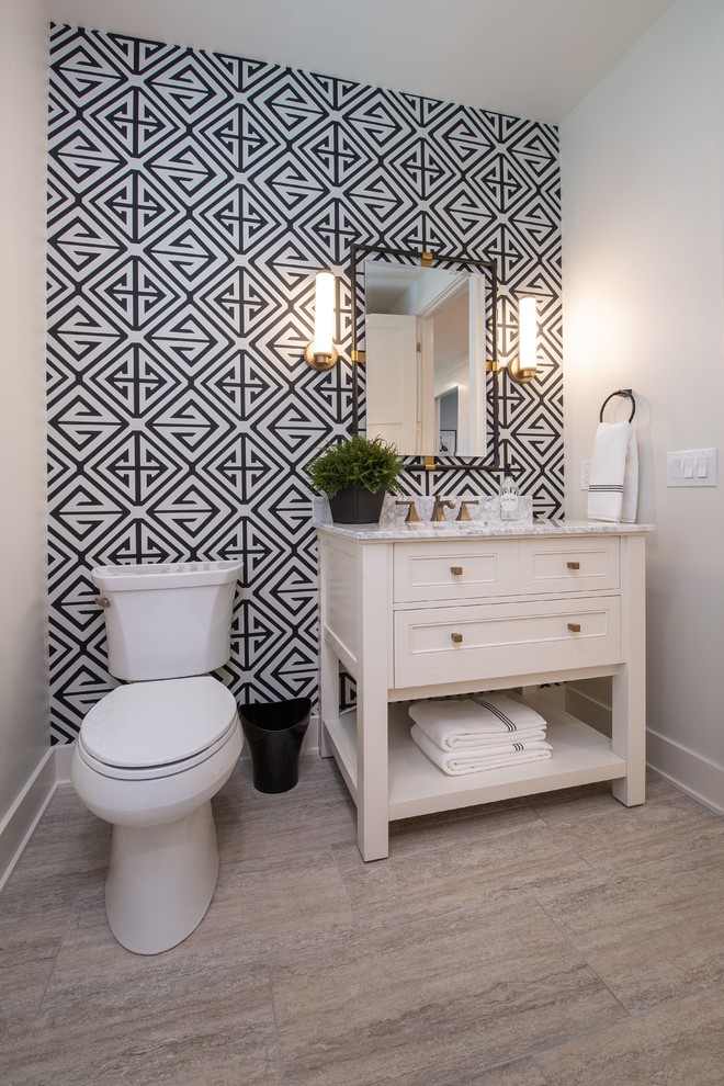 Photo of a beach style powder room in Grand Rapids with furniture-like cabinets, white cabinets, multi-coloured walls, grey floor and white benchtops.