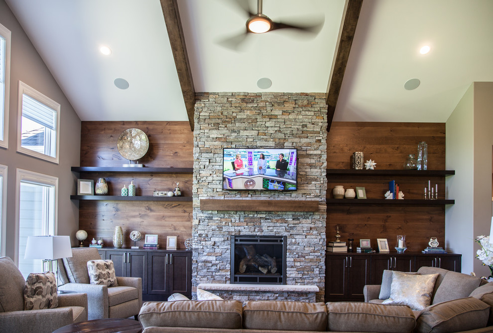This is an example of a transitional family room in Other with beige walls, dark hardwood floors, a standard fireplace, a stone fireplace surround, a wall-mounted tv and brown floor.