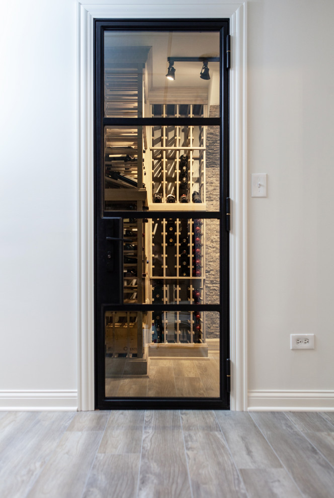Small transitional wine cellar in Chicago with laminate floors, storage racks and grey floor.