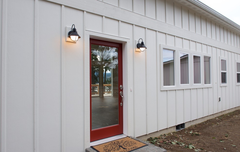 This is an example of a mid-sized contemporary front door in Seattle with white walls, a single front door and a glass front door.