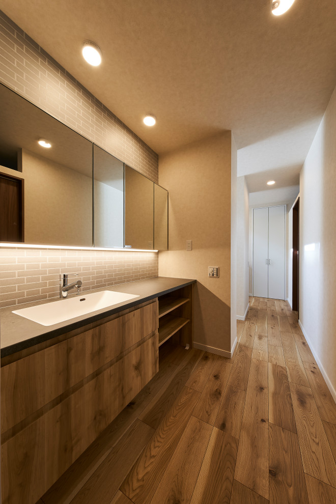 На фото: туалет в восточном стиле с серыми фасадами, серой плиткой, серыми стенами, серым полом, акцентной стеной, потолком с обоями и обоями на стенах