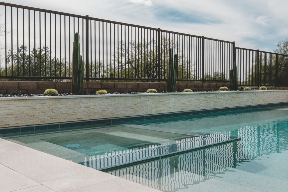 Esempio di una piscina a sfioro infinito minimalista rettangolare dietro casa con una vasca idromassaggio e pavimentazioni in pietra naturale