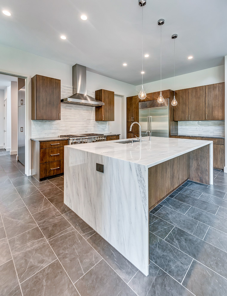 Design ideas for a modern eat-in kitchen in Dallas with an undermount sink, flat-panel cabinets, medium wood cabinets, quartz benchtops, white splashback, marble splashback, stainless steel appliances, porcelain floors, with island and grey floor.