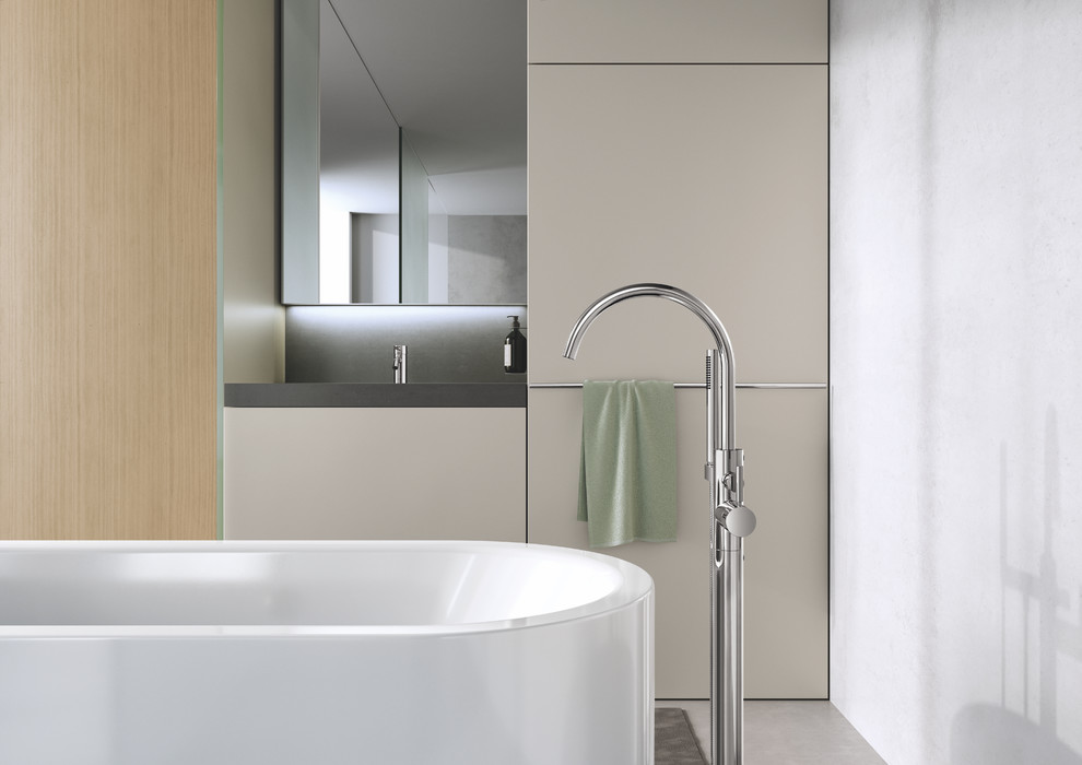 Photo of a mid-sized modern 3/4 bathroom in Dortmund with flat-panel cabinets, beige cabinets, a freestanding tub, an open shower, white tile, white walls, concrete floors, an integrated sink, grey floor and black benchtops.