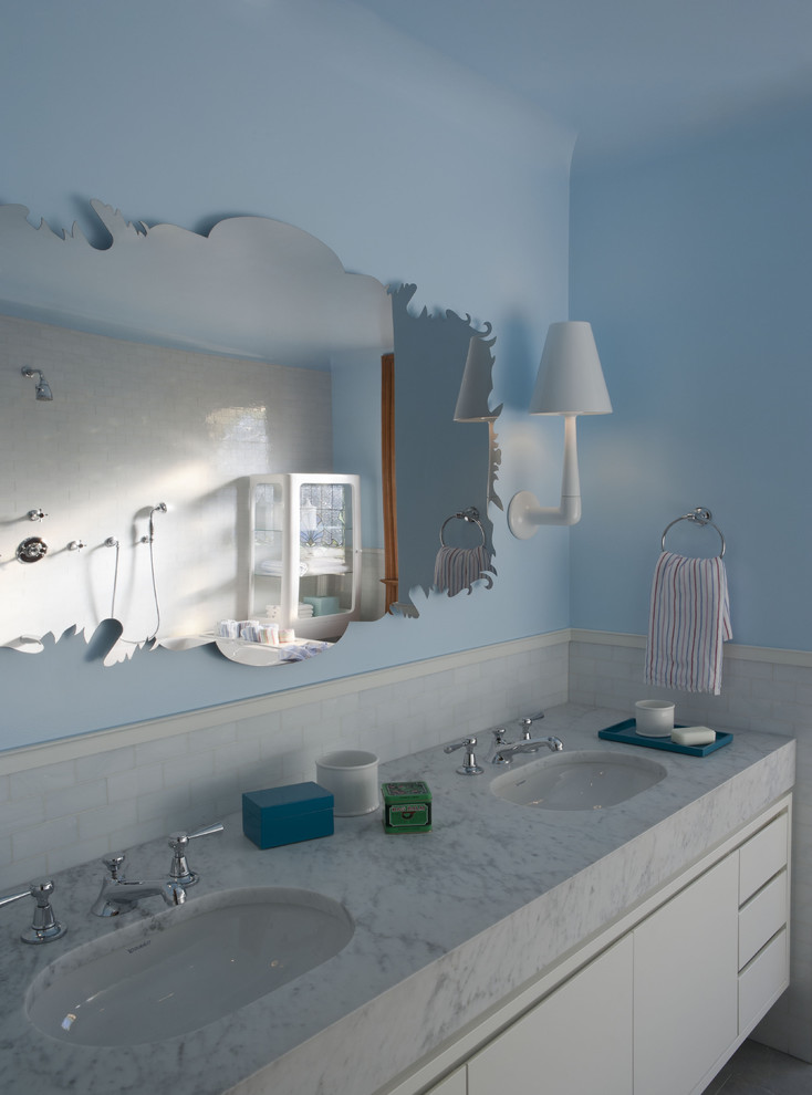 Photo of a contemporary bathroom in New York with flat-panel cabinets and white cabinets.