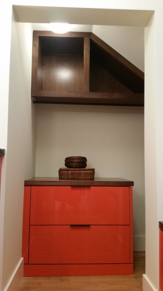 Bild på en mellanstor funkis garderob, med släta luckor och orange skåp