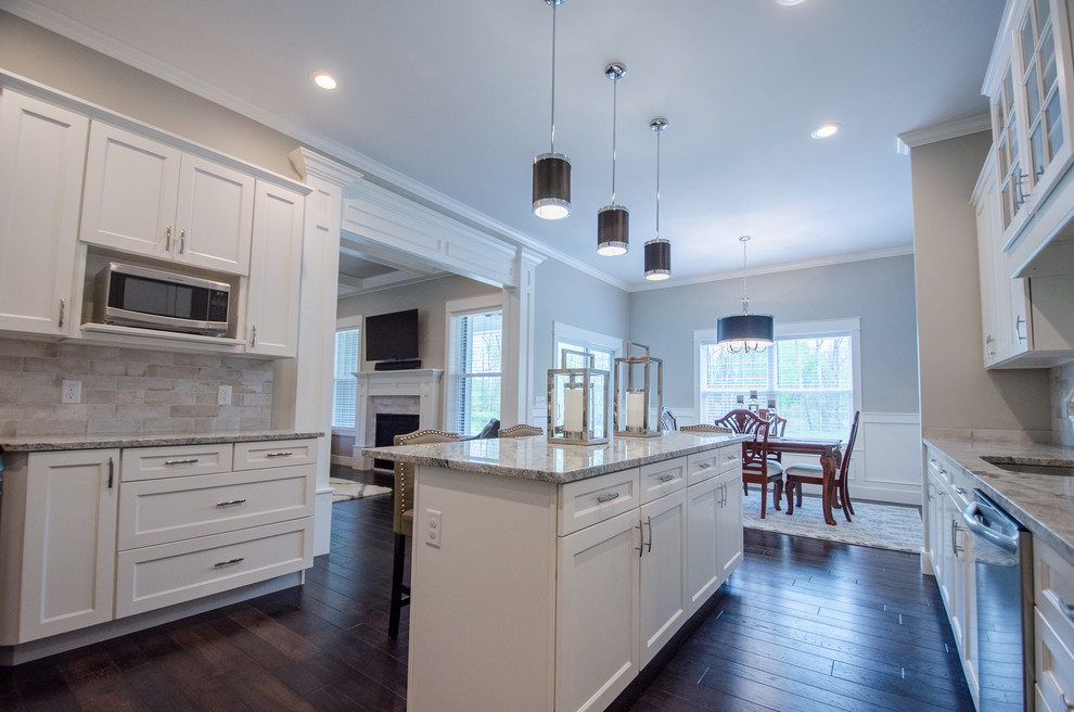 Inspiration for a mid-sized transitional single-wall dark wood floor eat-in kitchen remodel with recessed-panel cabinets, white cabinets, granite countertops, stone tile backsplash, stainless steel appliances and an island
