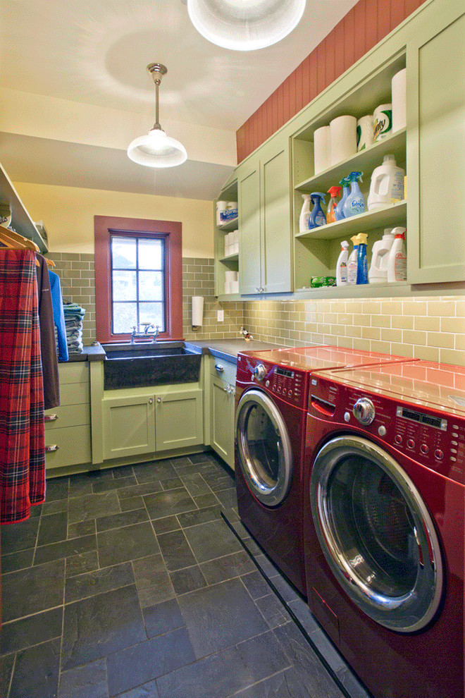 This is an example of a mid-sized country l-shaped dedicated laundry room in Salt Lake City with shaker cabinets, green cabinets, a farmhouse sink, concrete benchtops, white walls, slate floors and a side-by-side washer and dryer.
