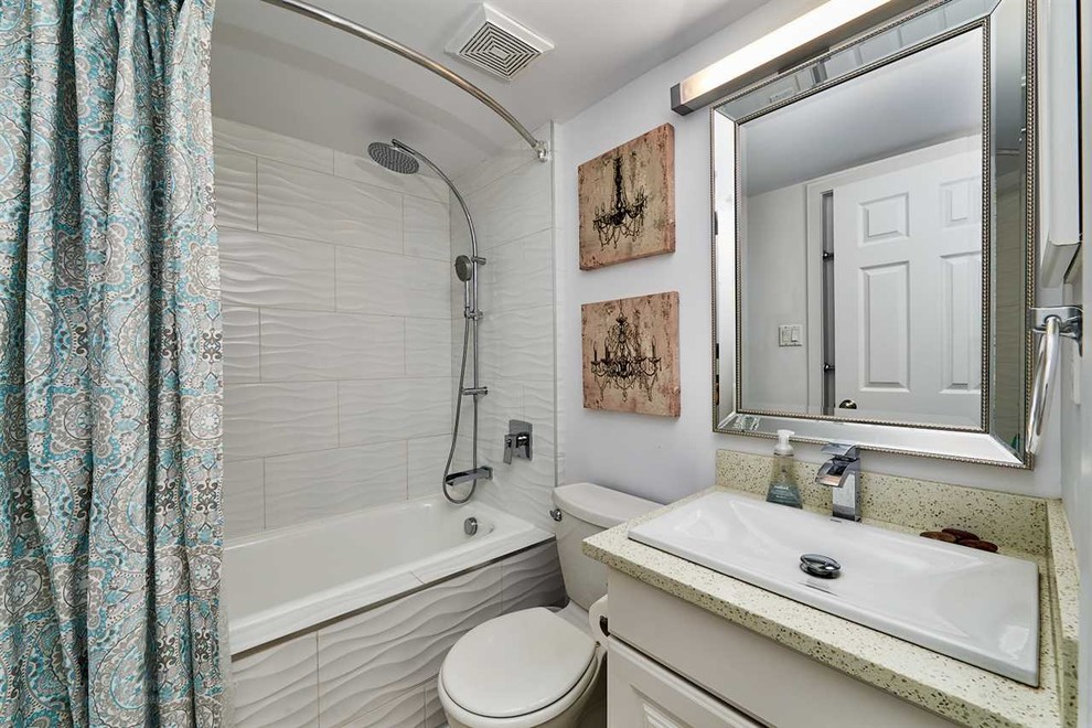 Inspiration for a small modern 3/4 bathroom in Vancouver with raised-panel cabinets, white cabinets, a drop-in tub, a shower/bathtub combo, a two-piece toilet, white tile, ceramic tile, white walls, linoleum floors, a drop-in sink, engineered quartz benchtops and a shower curtain.