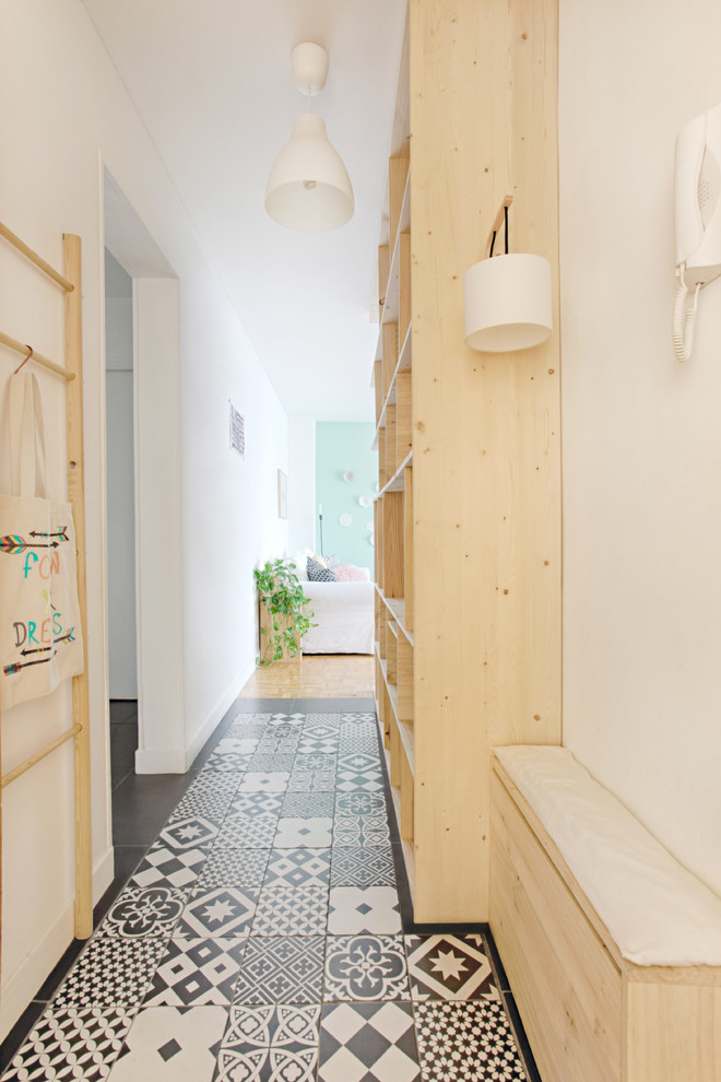 Photo of a mid-sized scandinavian hallway in Paris with white walls and ceramic floors.