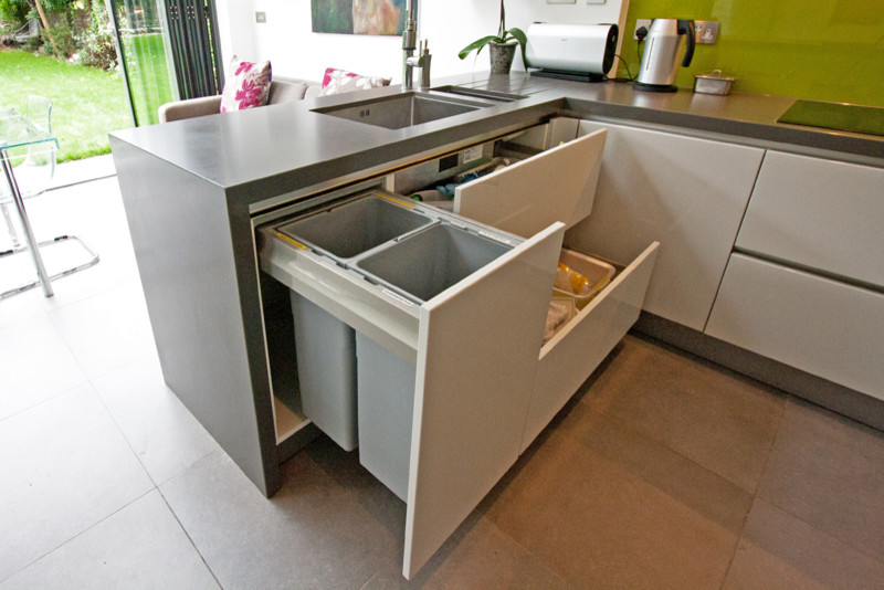 This is an example of a modern kitchen in London with grey cabinets and a peninsula.