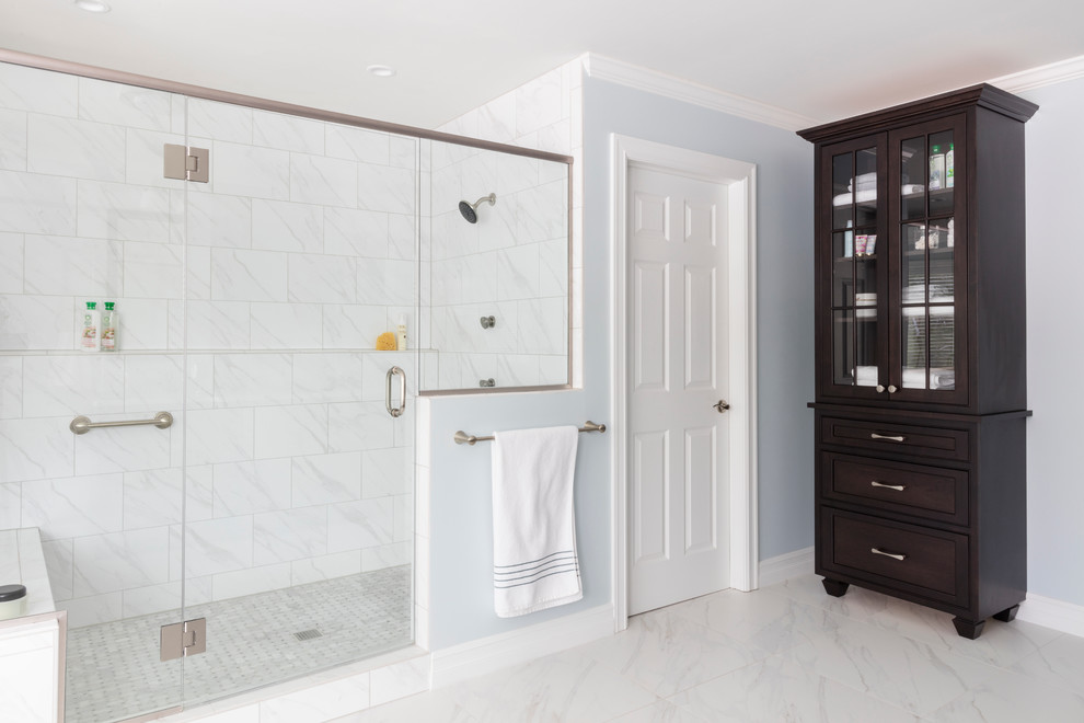 Design ideas for a transitional master bathroom in New York with beaded inset cabinets, dark wood cabinets, a freestanding tub, a two-piece toilet, white tile, porcelain tile, blue walls, porcelain floors, an undermount sink and engineered quartz benchtops.