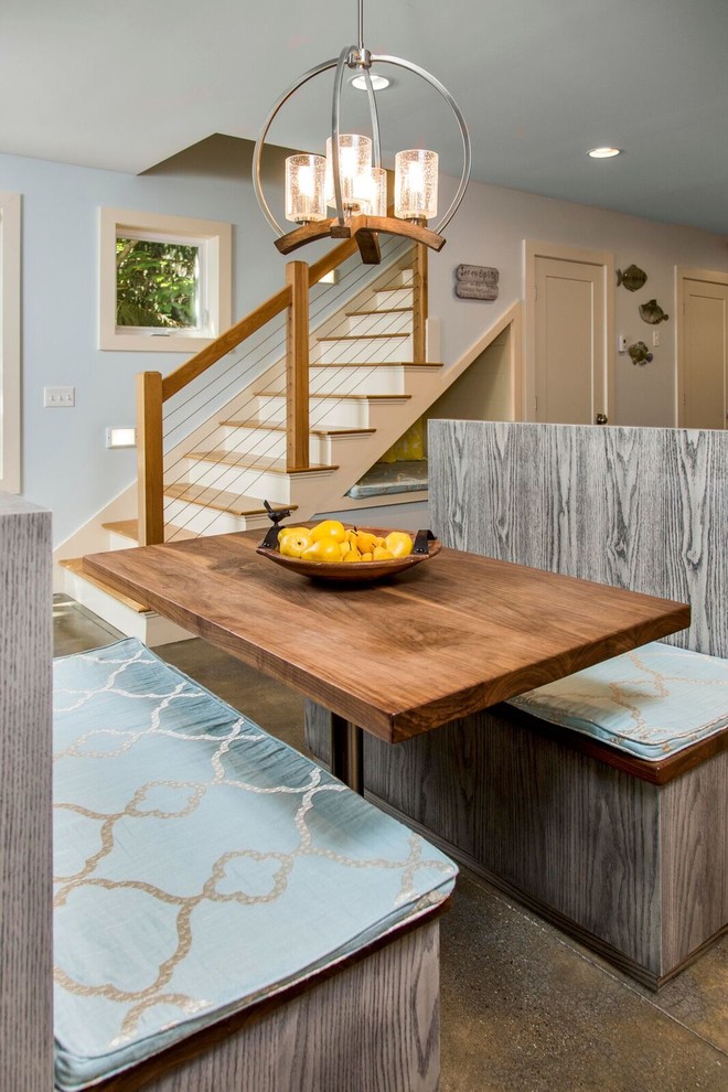 Design ideas for a large beach style single-wall open plan kitchen in Portland Maine with an undermount sink, shaker cabinets, white cabinets, wood benchtops, white splashback, stone slab splashback, stainless steel appliances, concrete floors and with island.