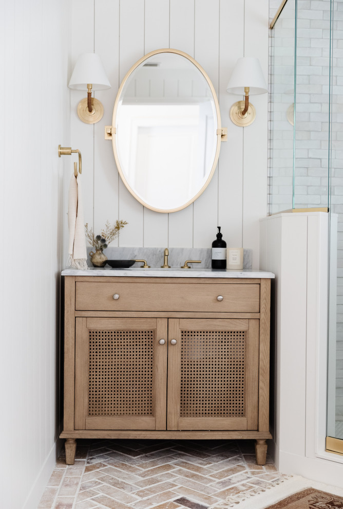 Bild på ett mellanstort vintage grå grått badrum, med skåp i ljust trä, en hörndusch, en toalettstol med separat cisternkåpa, vit kakel, perrakottakakel, vita väggar, tegelgolv, marmorbänkskiva, rött golv och dusch med gångjärnsdörr