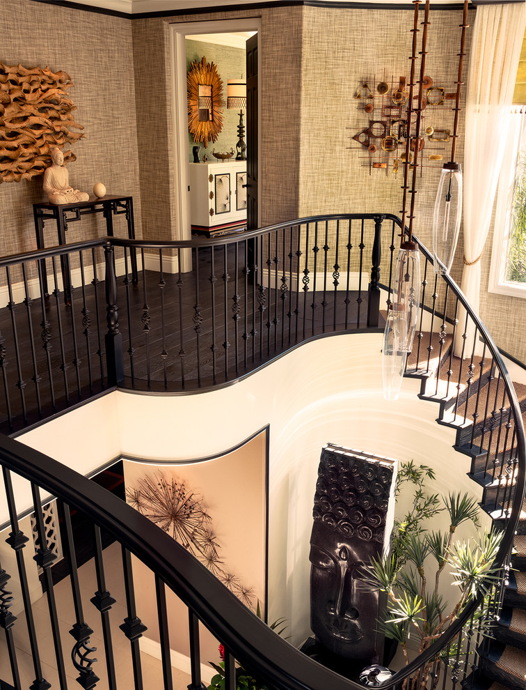 Tropical carpeted curved staircase in Las Vegas with wood risers and wood railing.