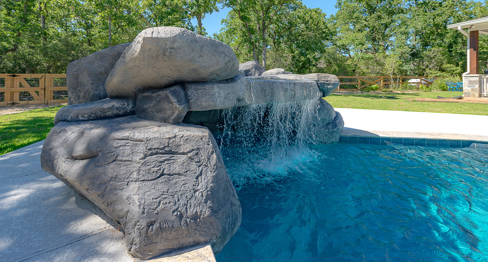 Design ideas for a large traditional backyard custom-shaped natural pool in Other with a hot tub and concrete slab.