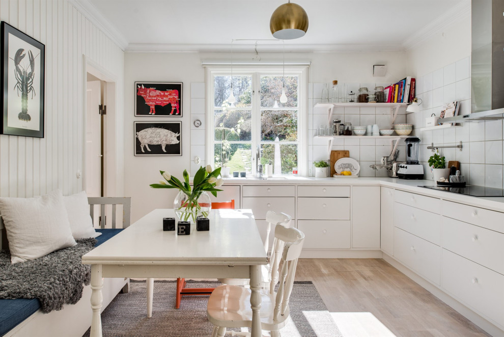 Design ideas for a mid-sized scandinavian l-shaped eat-in kitchen in Gothenburg with flat-panel cabinets, white cabinets, white splashback, light hardwood floors, no island and beige floor.