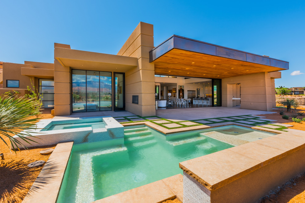 Photo of a large contemporary backyard custom-shaped pool in Salt Lake City with a hot tub and concrete pavers.