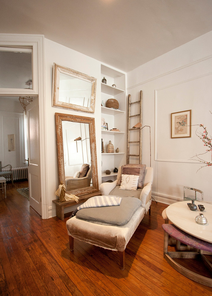 This is an example of a traditional living room in New York with white walls and medium hardwood floors.