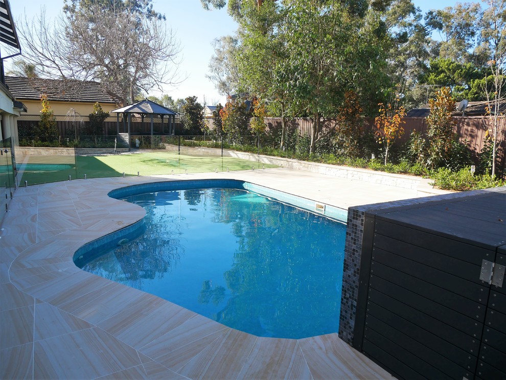 Photo of a mid-sized modern backyard kidney-shaped natural pool in Newcastle - Maitland with a water feature and tile.