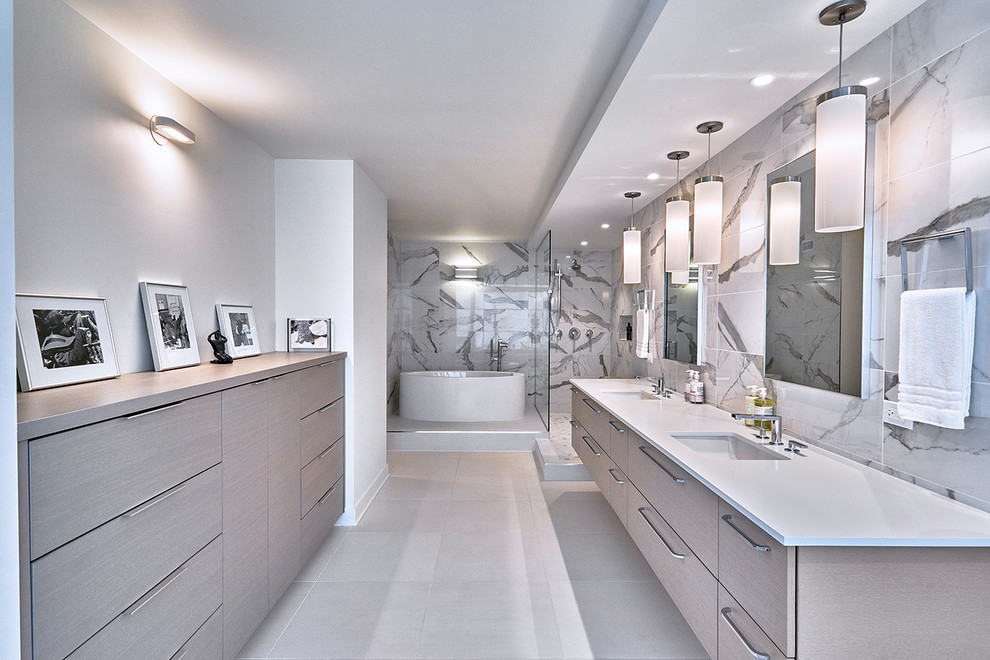 Inspiration for an expansive modern master bathroom in Chicago with flat-panel cabinets, grey cabinets, a freestanding tub, an open shower, a one-piece toilet, white tile, porcelain tile, white walls, porcelain floors, an undermount sink, engineered quartz benchtops, white floor, an open shower and white benchtops.