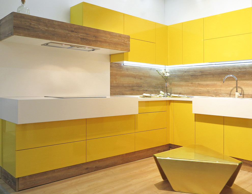 Inspiration for an u-shaped eat-in kitchen in Moscow with yellow cabinets and solid surface benchtops.