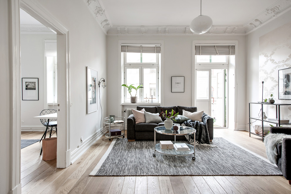 Photo of a large scandinavian formal living room in Gothenburg with white walls, no fireplace, light hardwood floors and beige floor.