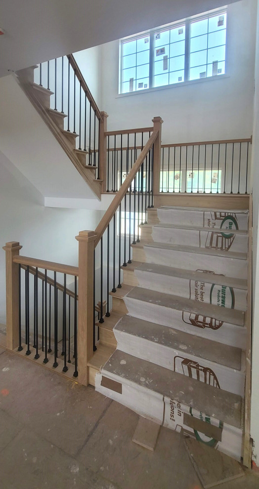 На фото: большая угловая деревянная лестница в современном стиле с деревянными ступенями и перилами из смешанных материалов с