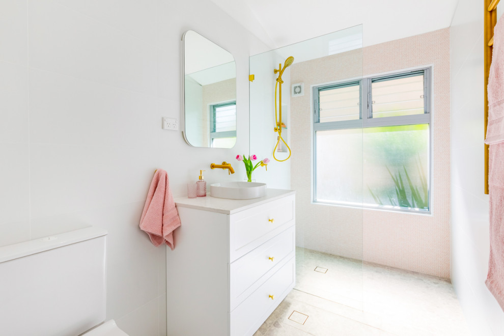 Medium sized modern family bathroom in Sydney with shaker cabinets, white cabinets, a walk-in shower, a two-piece toilet, pink tiles, mosaic tiles, white walls, porcelain flooring, a vessel sink, grey floors, an open shower, white worktops, a wall niche, a single sink and a freestanding vanity unit.
