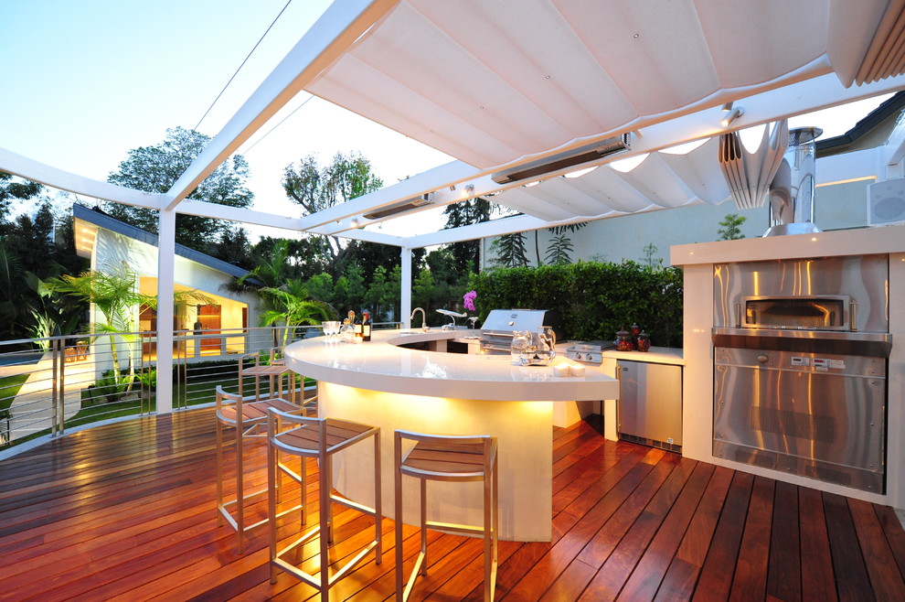Photo of a mid-sized modern backyard deck in Los Angeles with an awning.