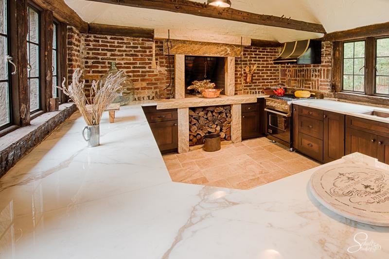 Inspiration for a large rustic u-shaped travertine floor eat-in kitchen remodel with an undermount sink, shaker cabinets, dark wood cabinets, marble countertops, red backsplash, stainless steel appliances and a peninsula