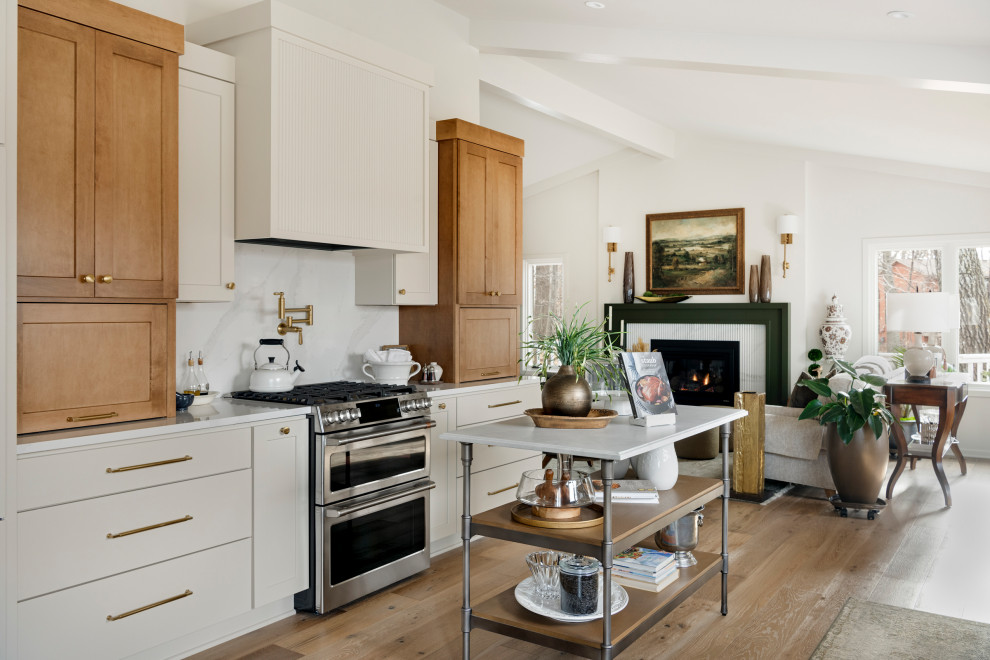 Example of a mid-sized transitional galley medium tone wood floor, brown floor and vaulted ceiling eat-in kitchen design in Minneapolis with an undermount sink, shaker cabinets, quartz countertops, white backsplash, subway tile backsplash, stainless steel appliances, an island and white countertops