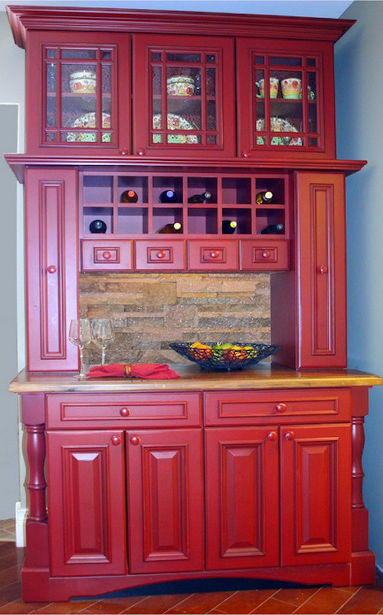 Small traditional single-wall home bar in Toronto with raised-panel cabinets, red cabinets, beige splashback and stone tile splashback.