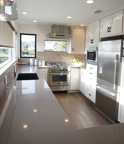 Modern galley kitchen with white shaker kitchen cabinet run, tall pantry tower, drawer bases, and stainless appliances maximizing storage
