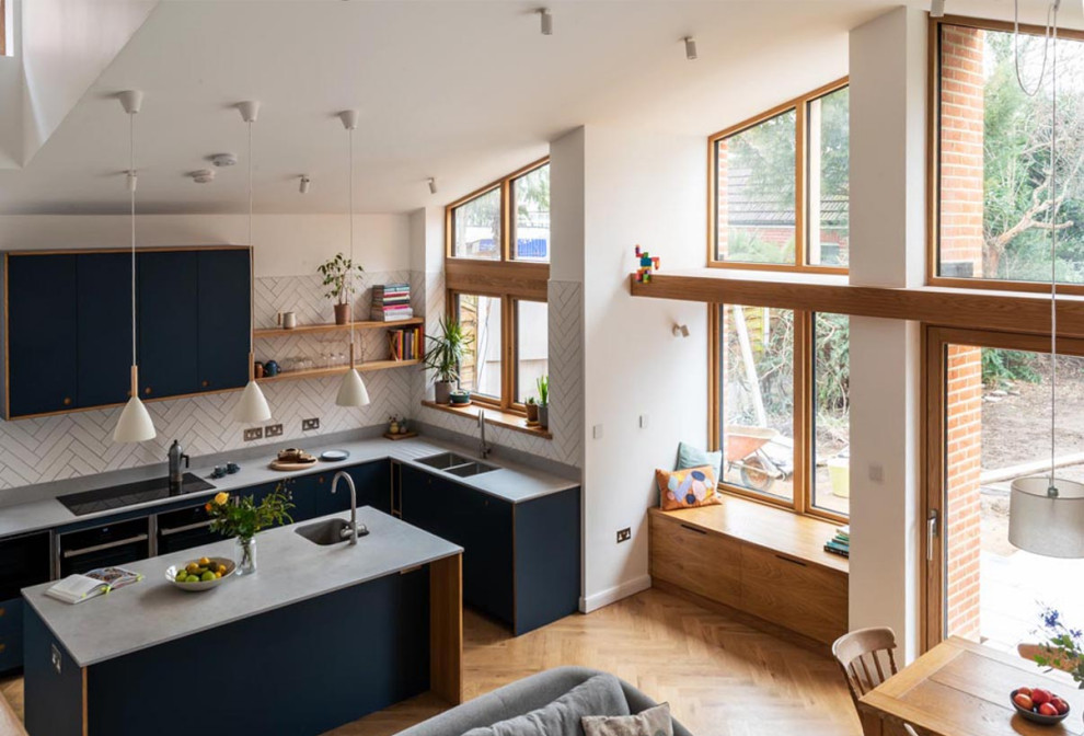 Geräumige Moderne Wohnküche mit weißer Wandfarbe, braunem Holzboden, Kaminofen, braunem Boden, gewölbter Decke und Ziegelwänden in London